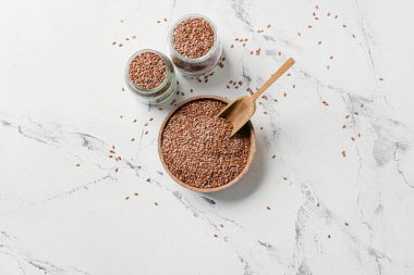 Beyaz arka planda keten tohumu kasesi ve kavanozları