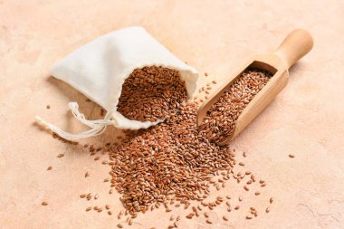 Renk arkaplanında keten tohumu kepçesi ve poşeti