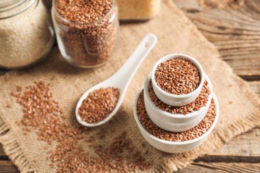 Tahta masanın üzerinde keten tohumları olan kompozisyon.