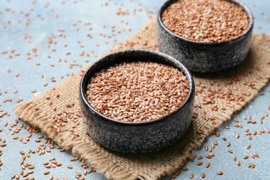 Renk arkaplanında keten tohumları olan kaseler, yakın plan