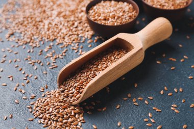 Koyu fonda keten tohumu dolu kaplar, yakın plan.