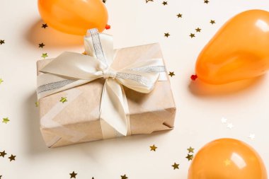 Hava balonları, hediye kutusu ve renkli arka planda konfeti.