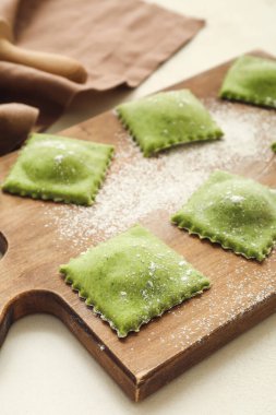 Masada çiğ ravioli ile ahşap tahta.