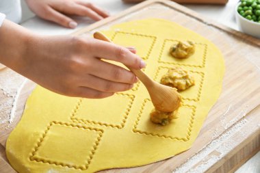 Kadın aşçı masada lezzetli ravioli yapıyor, yakın plan.
