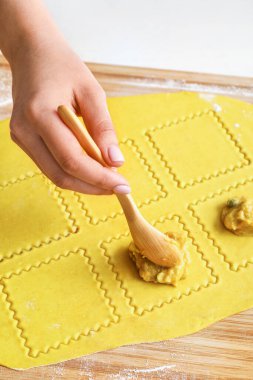 Kadın aşçı masada lezzetli ravioli yapıyor, yakın plan.