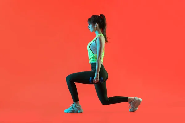 Sportliche Junge Frau Trainiert Mit Kurzhanteln Auf Farbigem Hintergrund — Stockfoto