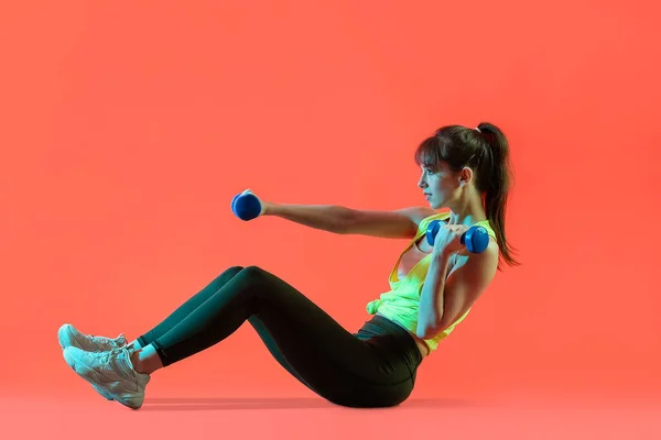 Sportliche Junge Frau Trainiert Mit Kurzhanteln Auf Farbigem Hintergrund — Stockfoto