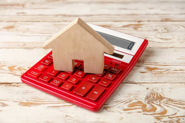 Calculadora Con Figura Casa Sobre Fondo Madera Claro — Foto de Stock