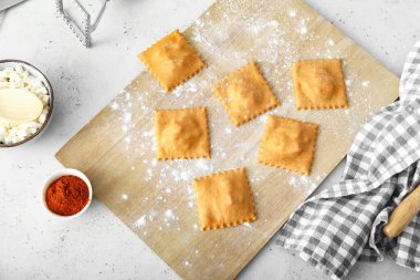 Masada çiğ ravioli ile ahşap tahta.