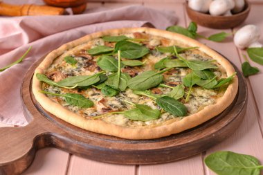 Ahşap arka planda ıspanaklı lezzetli vejetaryen pizza, yakın plan.