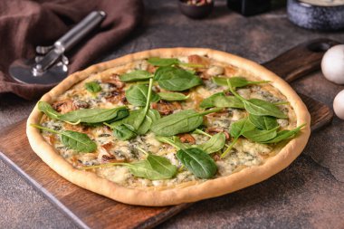 Arkaplanda ıspanaklı lezzetli vejetaryen pizza.