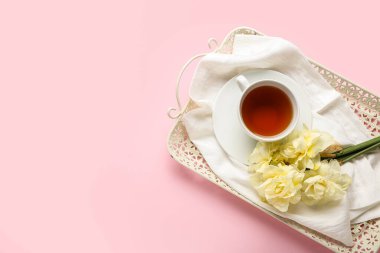Çay tepsisi ve güzel narcissus çiçekleri renkli arka planda.