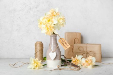 Güzel narsisli çiçekler ve açık arkaplanlı hediye kutuları.