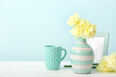 Renkli arka planda güzel narsisus çiçekleri, fincan ve çerçeveli kompozisyon