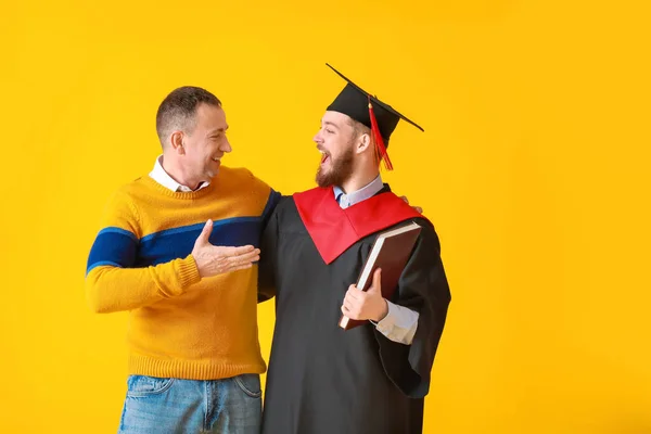 Glücklicher Männlicher Abschlussschüler Mit Seinem Vater Auf Farbigem Hintergrund — Stockfoto