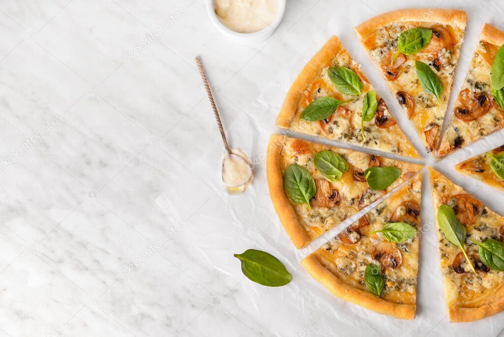 Slices of vegetarian pizza with spinach and mushrooms on light table