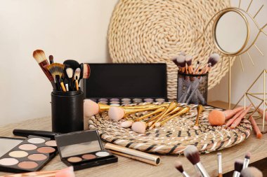 Makyaj fırçaları ve kozmetik ürünleri makyaj masasında.