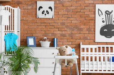 Modern çocuk odasının içinde beslenme koltuğu olan şık bir yer.