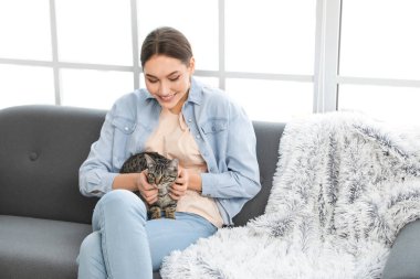 Evinde sevimli kedisi olan güzel genç bir kadın.