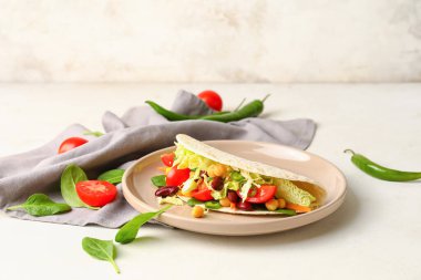 Hafif arka planda lezzetli vejetaryen taco tabağı.