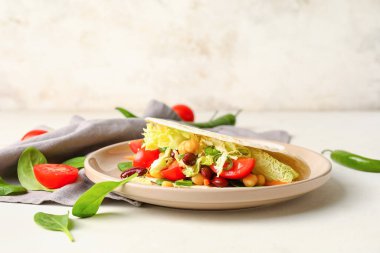 Hafif arka planda lezzetli vejetaryen taco tabağı.