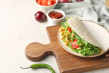 Hafif arka planda lezzetli vejetaryen taco ve soslu pano.