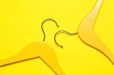 Renkli arka planda şık elbise askıları, yakın plan