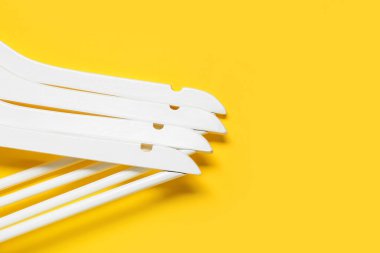 Renkli arka planda şık elbise askıları, yakın plan