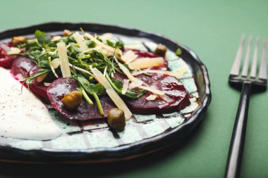 Renkli arka planda leziz pancar carpaccio tabağı, yakın plan.