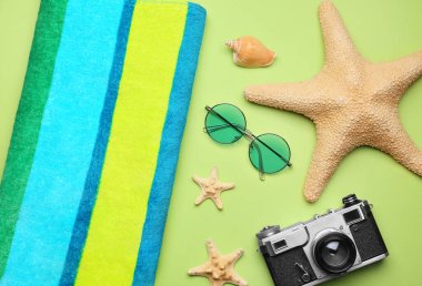 Havlu, fotoğraf makinesi, güneş gözlüğü ve deniz yıldızları.