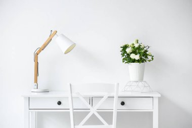 Güller tencerede, lambalar ışık duvarının yanında.