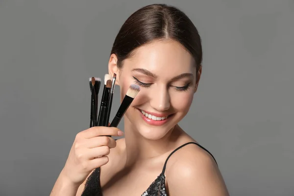Beautiful Young Woman Makeup Brushes Grey Background — Stock Photo, Image