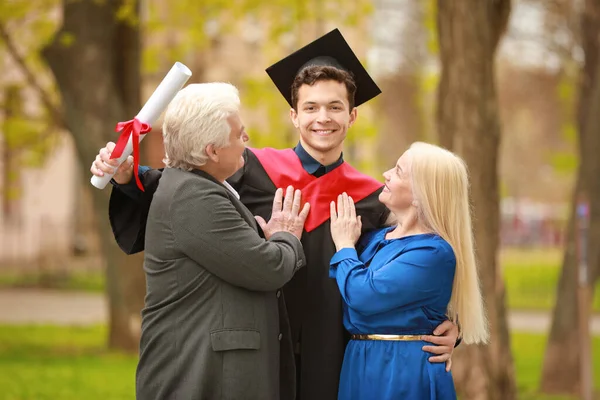 Happy young man with his parents on graduation day