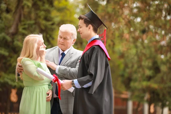 Happy young man with his parents on graduation day