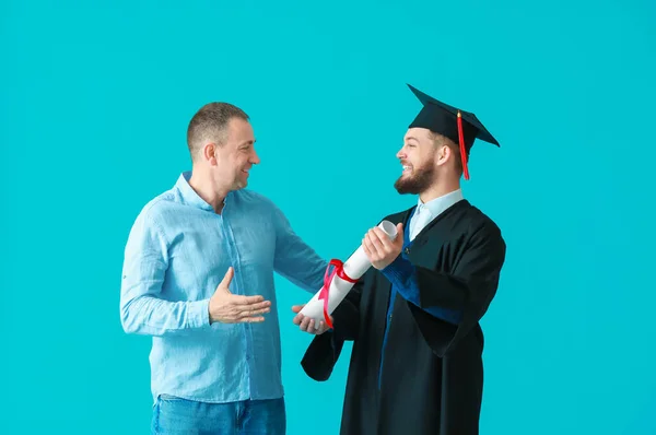 Glücklicher Männlicher Abschlussschüler Mit Seinem Vater Auf Farbigem Hintergrund — Stockfoto