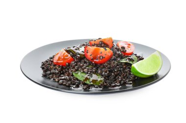 Beyaz arka planda lezzetli pişmiş mercimek ve sebzeli tabak.