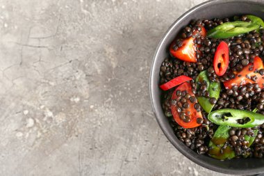 Lezzetli pişmiş mercimek ve arkaplanda sebzeli kase.