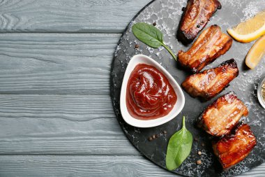 Lezzetli barbekü soslu kase ve koyu ahşap arka planda kızarmış domuz eti.