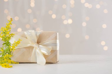 Bulanık ışıklara karşı hediye kutusu ve güzel çiçekler.