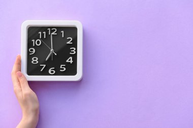 Renk arkaplanında şık bir saate sahip kadın eli, yakın plan