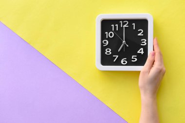 Renk arkaplanında şık bir saate sahip kadın eli, yakın plan