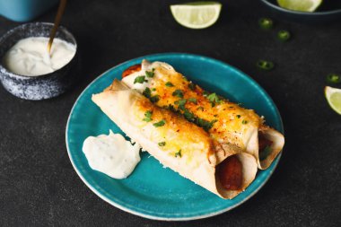 Koyu arkaplanda lezzetli pişmiş enchilada tabağı.