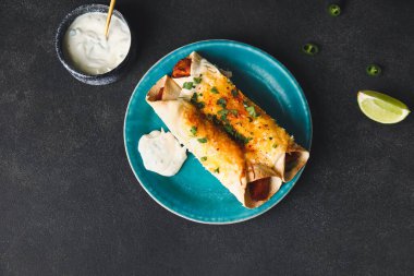 Koyu arkaplanda lezzetli pişmiş enchilada tabağı.