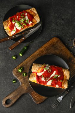 Koyu arkaplanda lezzetli pişmiş enchilada tabakları.