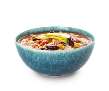 Beyaz arka planda bir kase lezzetli tavuk enchilada çorbası.