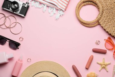 Sahildeki aksesuarlar ve renk arkaplanındaki kozmetik ürünlerden yapılmış çerçeve