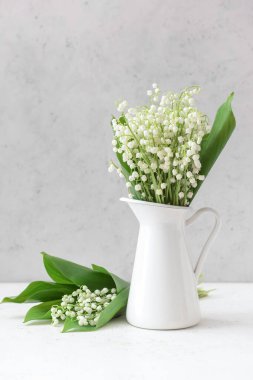 Işıklı arka planda güzel çiçekli bir sürahi.