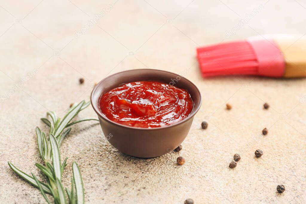 Bowl with tasty barbecue sauce and silicone brush on light background