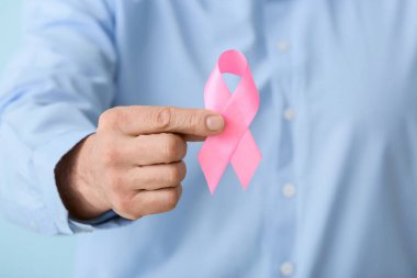 Pembe kurdeleli adam, yakın plan. Göğüs kanseri farkındalığı konsepti