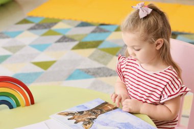 Odada kitap okuyan küçük kız.